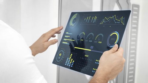 Profissional de TI analisando painel digital com indicadores de desempenho, representando a transformação da TI em área estratégica